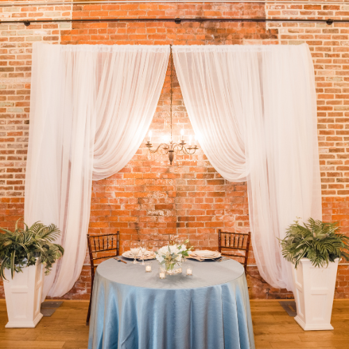 Set table in front of a lit chandelier 